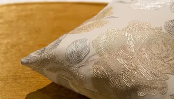 Zierkissen mit floralem Muster in Gold und Silber