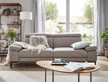 Graues Zweisitzer Sofa mit klappbaren Armlehnen und Kopfstützen.
