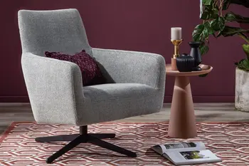 Grauer Sessel mit schwarzem Sternfuß vor einer beerefarbenen Wand.