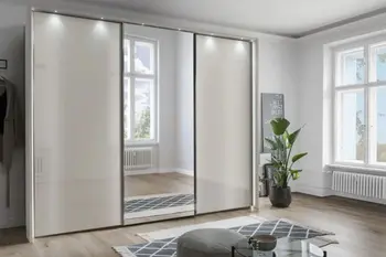 Moderner großer Schwebetürenschrank mit weißen Türen links und rechts und Spiegelfront in der Mitte und einer Beleuchtung oberhalb der Türen.