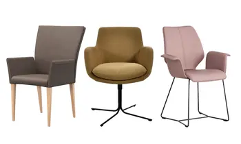 Drei verschiedene Stühle, ein brauner Lederstuhl mit Holzfüßen, ein Polsterstuhl zum drehen und ein rosafarbener Stuhl.