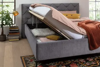 Ein Polsterbett mit aufgeklappten Bettkasten.