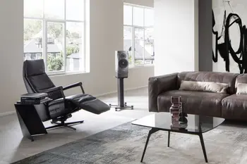 Schwarzer Relaxsessel mit ausgezogener Fußlehne neben einem braunen Ledersofa.