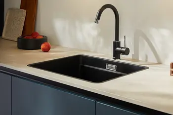 Schwarze Verbundwerkstoffspüle auf weißer Arbeitsplatte