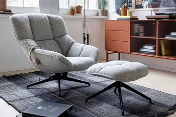 Grauer Sessel mit passendem Hocker. 