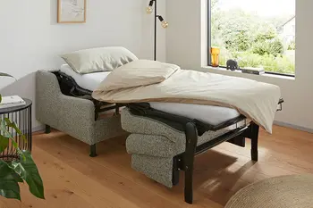 Grauer Schlafsessel, der zum Bett umgebaut ist.