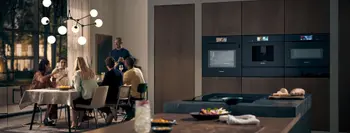 Gemütliches Abendessen mit modernen Elektrogeräten im Vordergrund