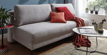 Graues Cord Sofa mit Schlaffunktion.