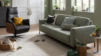 Ein Wohnzimmer mit einem grünen Sofa