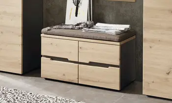 Garderobenbank aus Holz, Fronten sind grifflos und aus hellem Holz. Sitzkissen auf der Bank bietet eine Sitzmöglichkeit oder einen Ablageort.&nbsp;&nbsp;