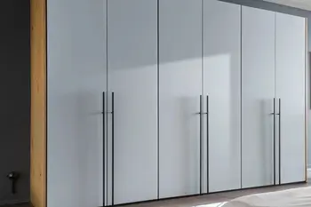 Großer Kleiderschrank mit grauen Drehtüren und langen Metallgriffen in silber.