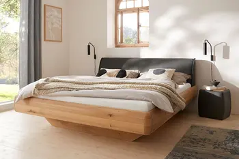 Designbett in schwebender Optik mit Holzrahmen und Leder Kopfteil. 