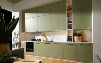 Große Küchenzeile mit hohen Hängeschränken, mit matten grünen Fronten.&nbsp;