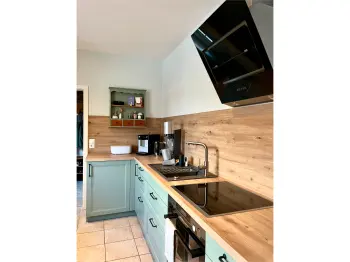 Salbeigrüne Küche mit Herd, Spüle und Küchengeräten