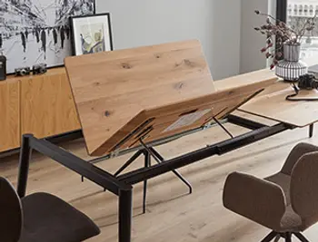 Ausziehtisch mit innovativer Mechanik in Aktion – massiver Holztisch mit integriertem Klappmechanismus und modernem Metallgestell für maximale Flexibilität im Essbereich.