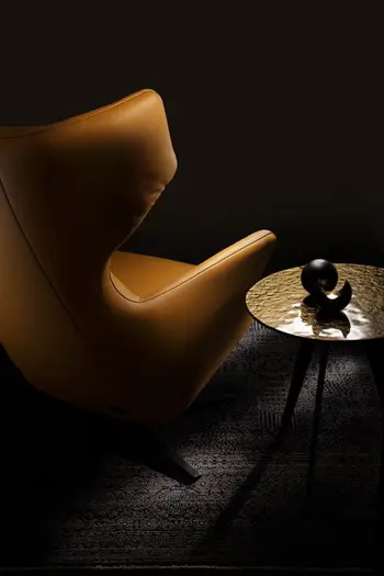 Rückansicht eines gelben Relaxsessels mit Lederbezug, der eine hohe Rückenlehne hat.