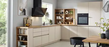 Cremefarbene Winkelkueche mit Dunstabzugshaube und Einbauofen.