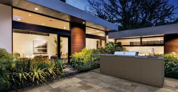 Schicke Outdoorkueche vor der Fassade eines modernen Luxuswohnhauses. 