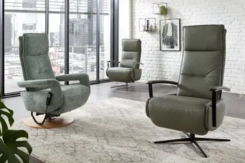 Drei grüne Relaxsessel in Leder und Stoff in einem hellen Raum.