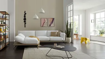 Helles Wohnzimmer mit hellem Ecksofa und Beistelltisch.