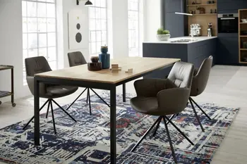 Modernes Esszimmer mit einem Holzesstisch und bequem gepolsterten Schalenstühlen mit grauem Lederbezug und schwarzem Fußgestell.