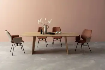 Moderner Massivholz Esstisch mit Schalenstühlen, die innen mit orangem Leder bezogen sind und außen mit beigem Stoff.