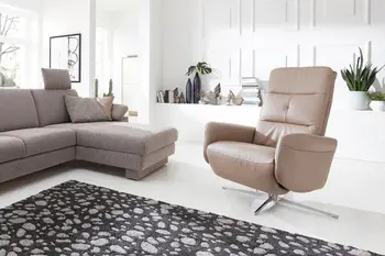 Beiger Sessel mit silbernem Drehfuß.