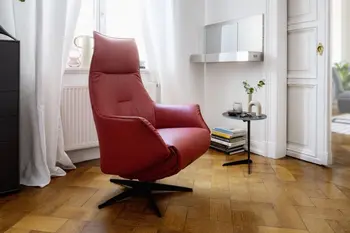Relaxsessel mit rotem Lederbezug in einem hellem Raum.