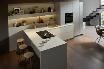 Graue Designküche mit Tresen in einem offenen Wohnbereich.