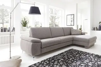 Graues Ecksofa mit silbernen Füßen in einem hellen Raum.