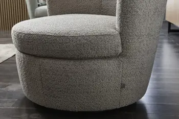 Sitzfläche eines grauen Boucle Sessels mit dickem Polster.