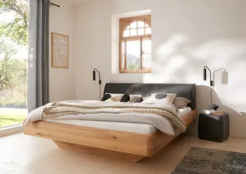 Harmonisches Schlafzimmer mit Doppelbett aus Massivholz und gepolstertem Kopfteil mit Lederbezug.