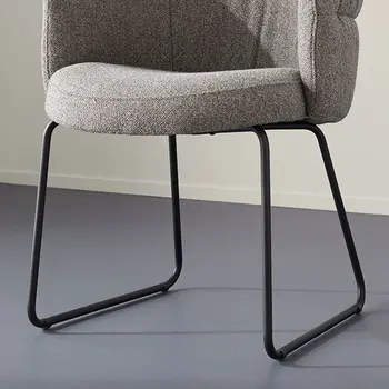 Kufengestell aus schwarzem Metall eines Esszimmerstuhls mit grauem Stoffbezug.