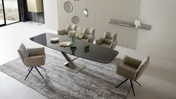 Modernes Esszimmer mit einem Esstisch mit schwarzer Keramik Tischplatte im Marmoroptik und beigen Lederstühlen um den Esstisch.