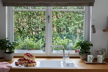 Küchenspüle, die direkt vor einem Fenster ist.