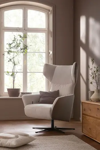 Beiger Relaxsessel mit Lederbezug in einem hellen gemütlichen Zimmer mit Pflanzen.