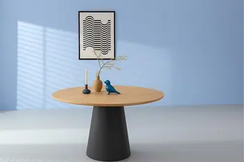 Runder Esstisch im Skandi Look in einem hellen Raum mit schwarzem Highboard..