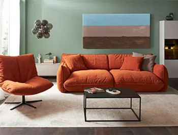 Bequemes Bigsofa in orange in hellem Raum. 
