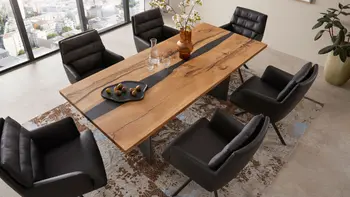 Design Esstisch aus Massivholz, der Akzente aus Epoxidhart hat in einem hellen Raum.