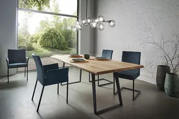 Modernes Esszimmer mit großem Holztisch und Stühlen mit dunkelblauem Stoffbezug.
