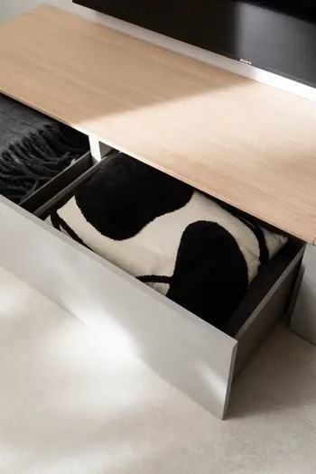 Graues Lowboard mit Holzabdeckplatte und großer Schublade.