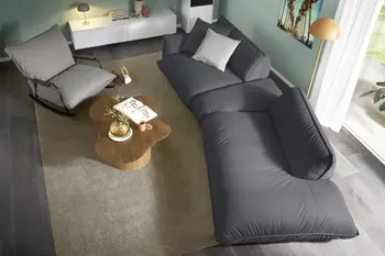 Asymmetrisches dunkelgraues Sofa mit verstellbarer Sitztiefe und hellgrauem Schaukelstuhl.