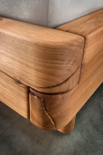 Ecke eines Massivholzbettes, bei dem die Maserungen des Holzes zu sehen sind.