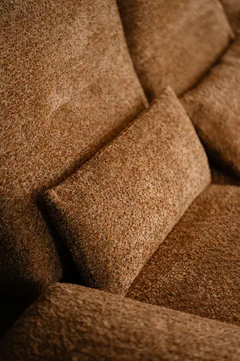 Dekokissen in passendem Stoff zu braunem Stoffsofa.