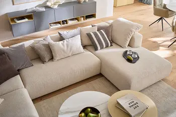 Zwischenelement in beiger Wohnlandschaft in hellem Wohnzimmer.