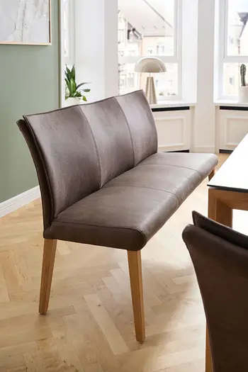 Klassische Sitzbank mit braunem Stoffbezug in hellem Esszimmer.