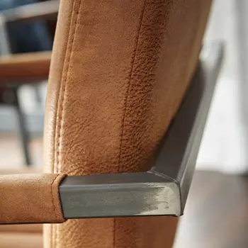 Gestell eines Freischwingers in eckiger Form hinter der Rückenlehne, die in Cognac ist.