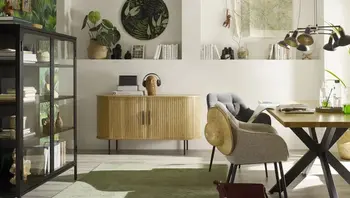 Modernes Holz-Sideboard mit Paneele-Optik inmitten eines gemütlich eingereichten Esszimmers mit Essbereich und Vitrine.&nbsp;