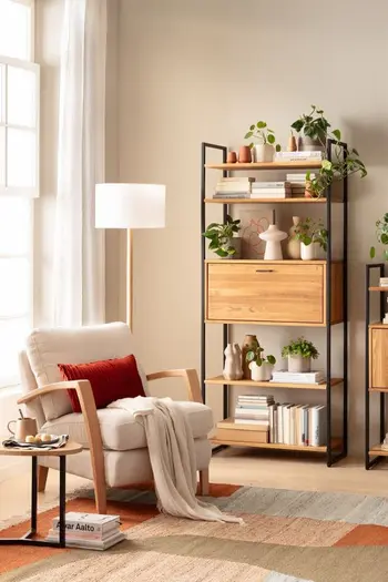 Beiger Sessel mit Armlehnen aus Holz in einem hellen gemütlichen Zimmer.