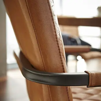 Abgerundetes Gestell eines Freischwingers in schwarzem Metall mit Rückenlehne in Leder in Cognacbraun.